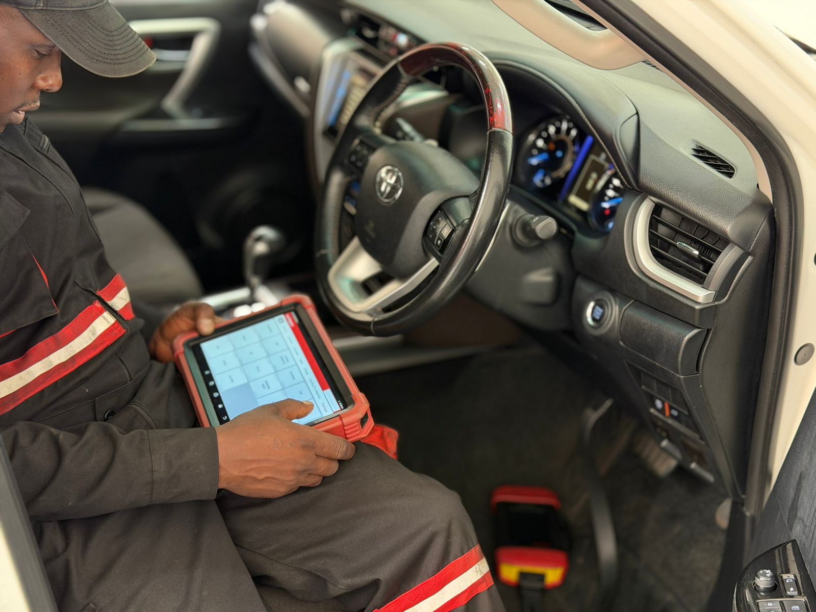 Technician running a computer diagnostic scan on a vehicle