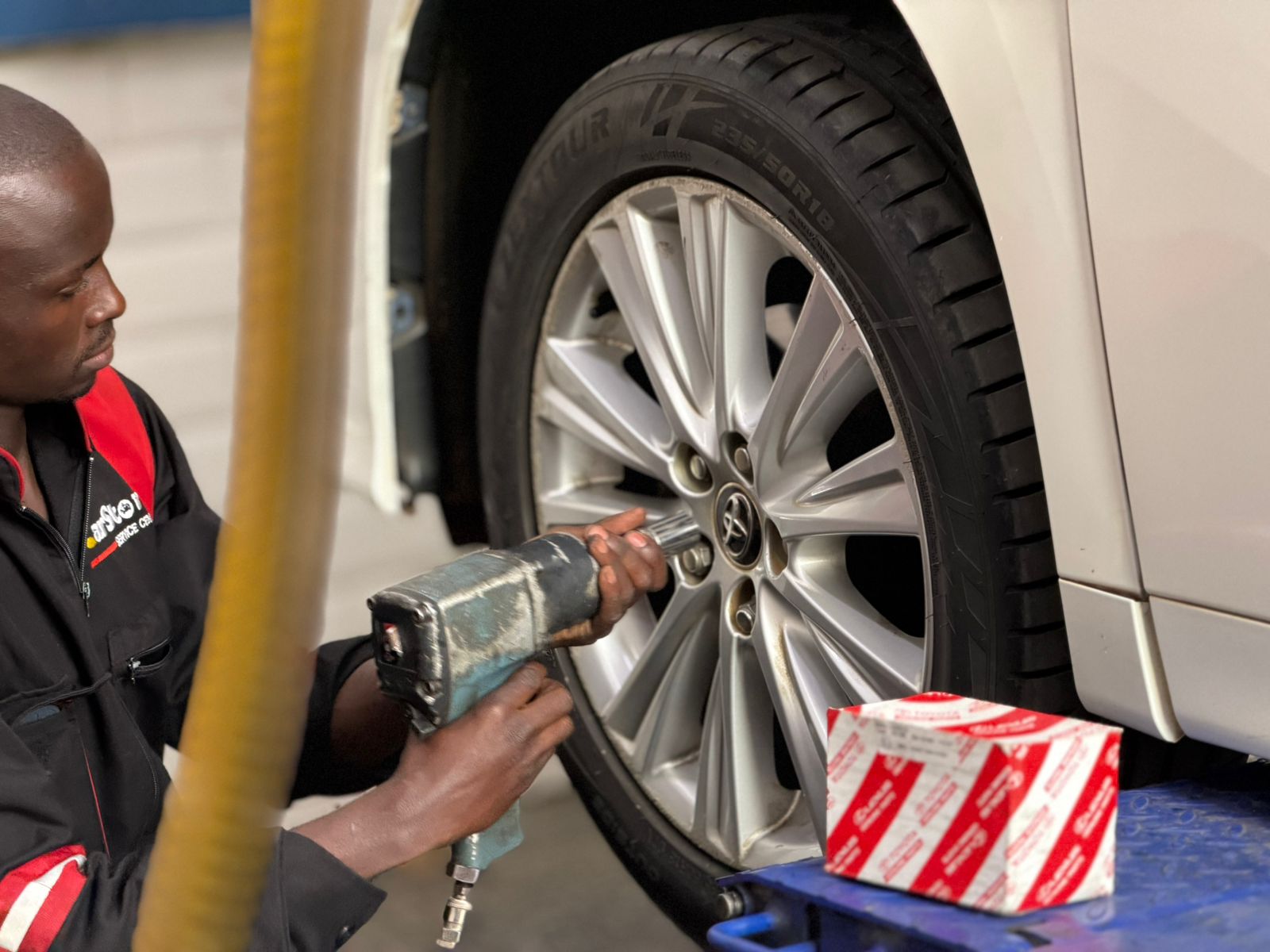 Technician fitting a wheel with an impact wrench